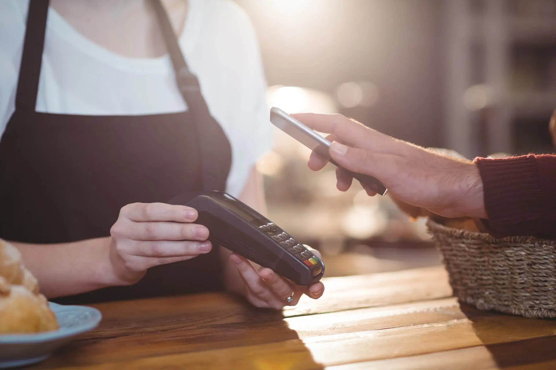 hospitality business owner delivering exceptional customer experience using POS device to accept payment