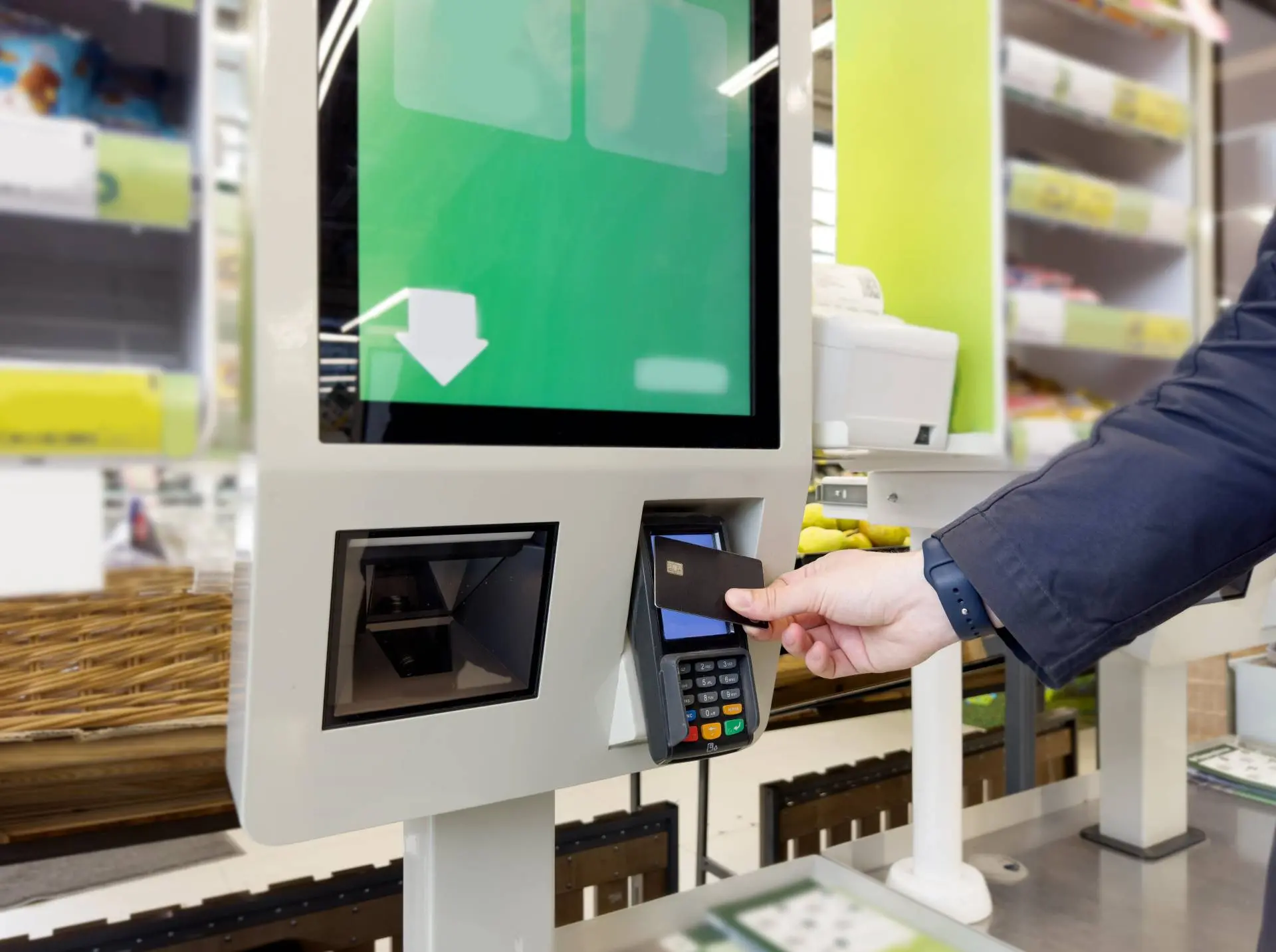 customer using self-checkout machine to pay for products at retail store