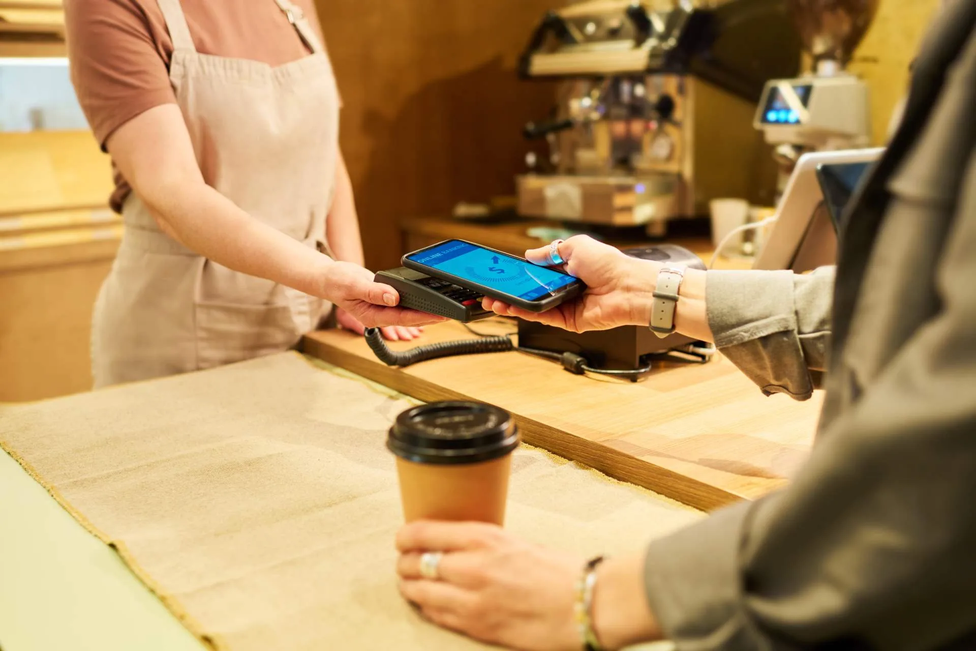 customer making contactless mobile payment on pos machine at coffee shop